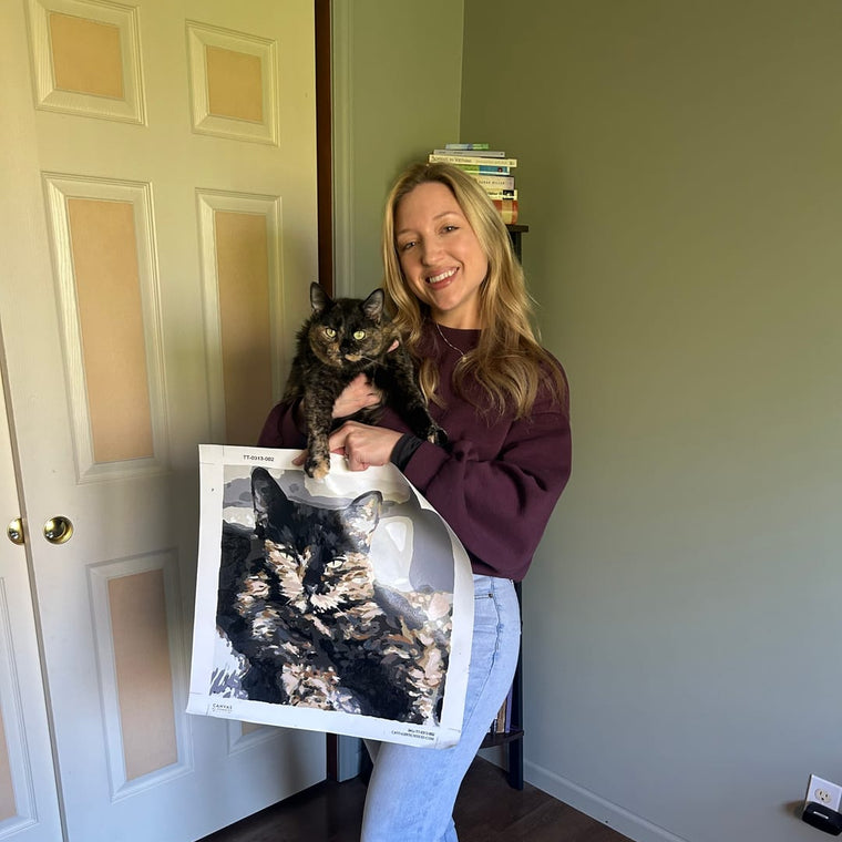 Clienta con su gata y el cuadro personalizado de pintar por números de ella
